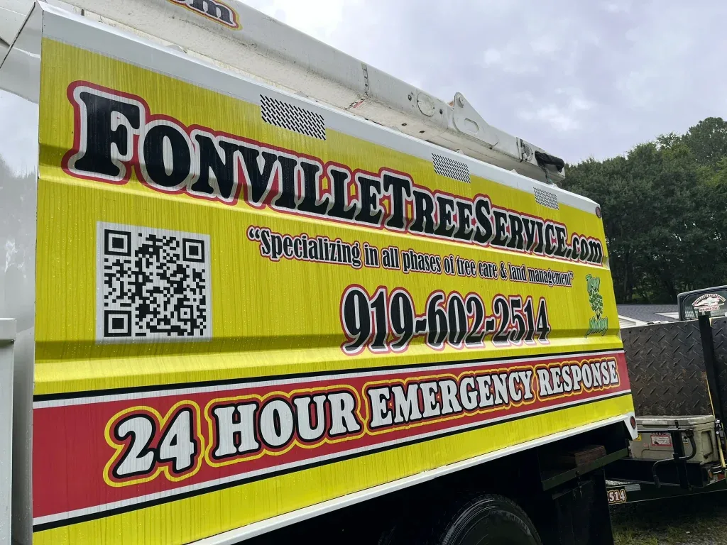 Fonvilletreeservice yellow branded bucket truck displaying company logo phone number and 24 hour emergency response signage in NC