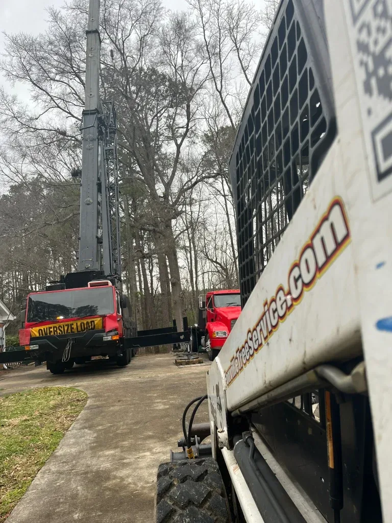 Fonvilletreeservice crane truck and skid steer equipment staged on residential driveway for tree service work in NC.