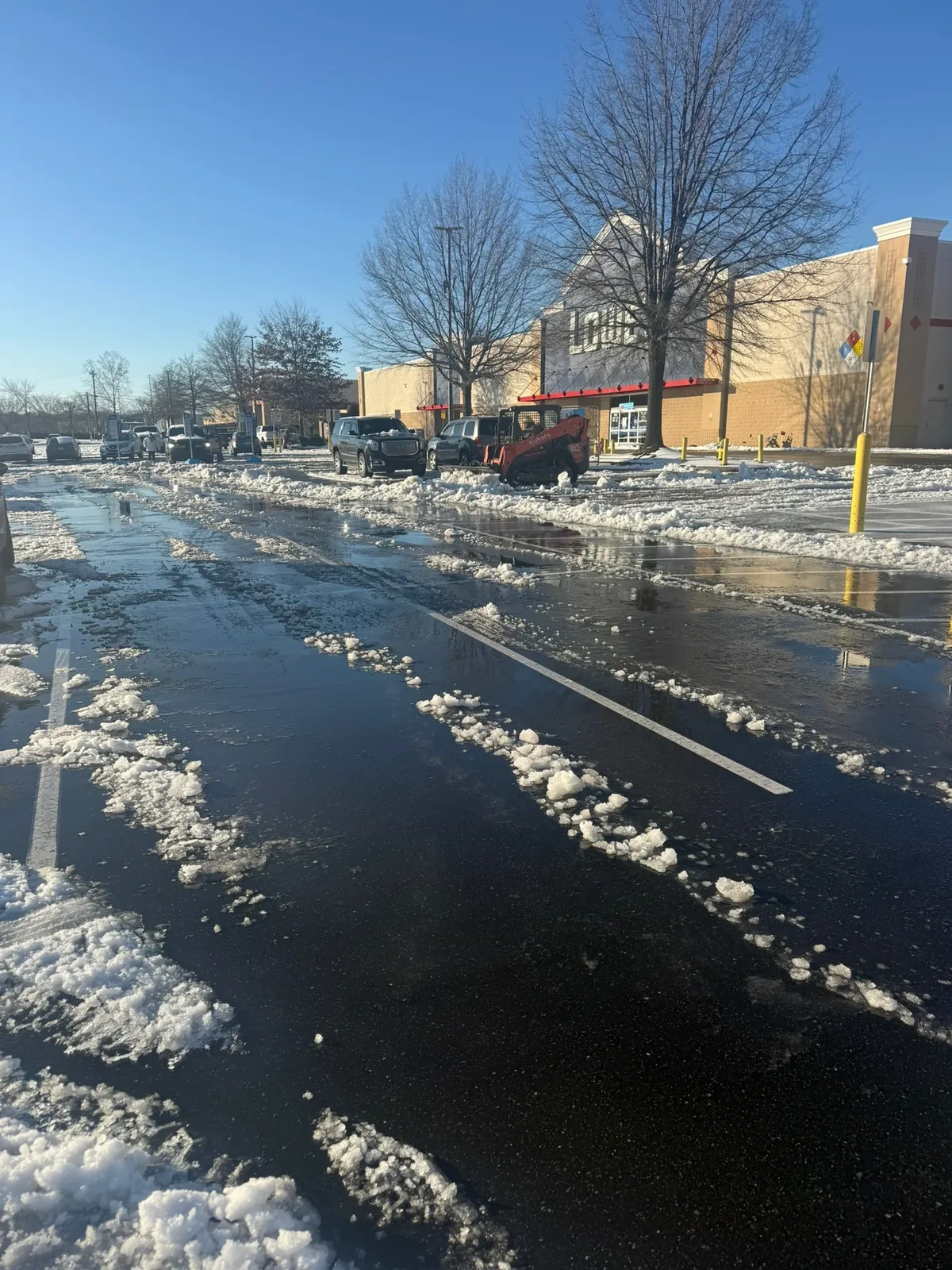 Melting snow cleared from a retail lot