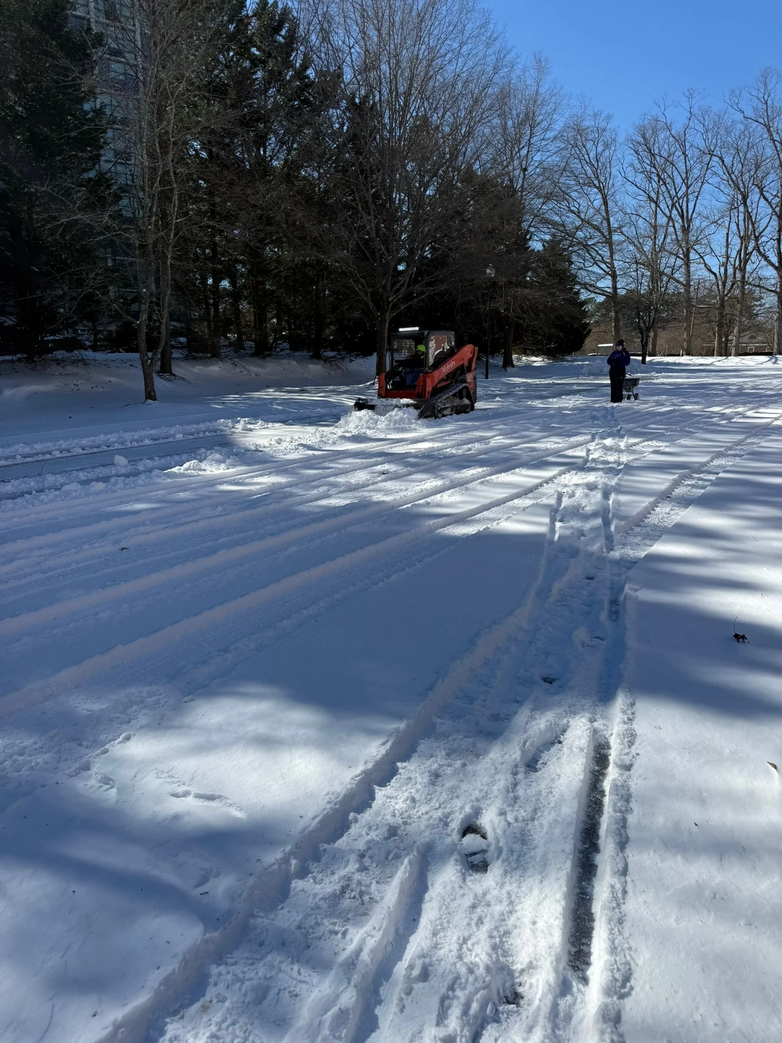 Fonvilletreeservice crew operating red compact track loader clearing snow from residential property in NC winter conditions