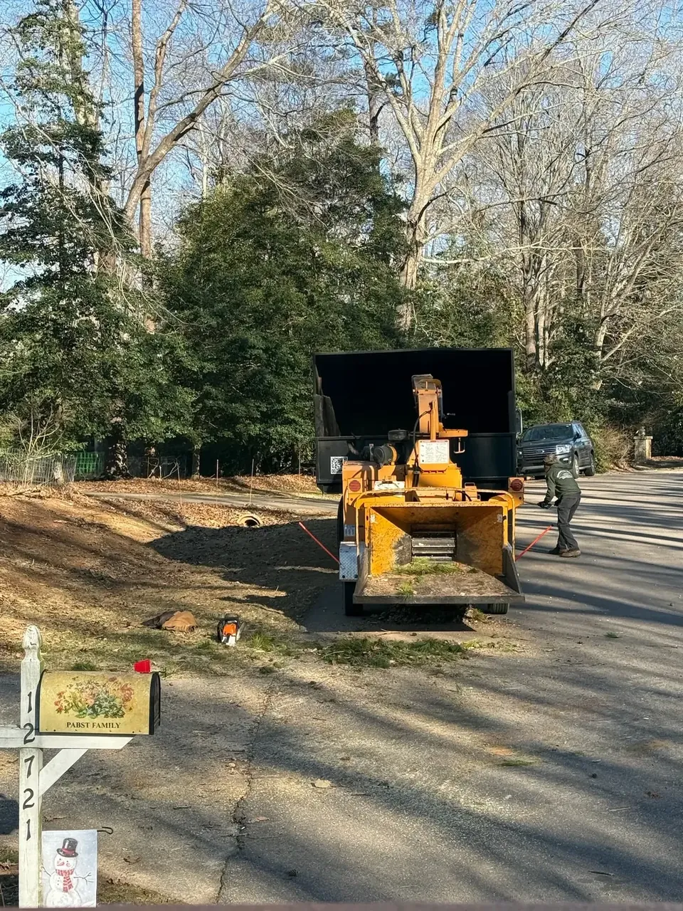 Chipper truck working through yard debris at the curb Chipper truck working through yard debris at the curb